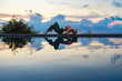 © mizuno555 - Young woman with long hair doing yoga early morning outdoor by the pool with sea view