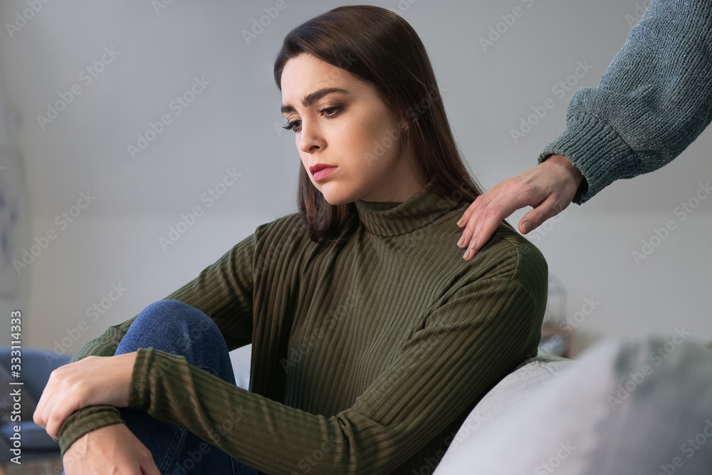 Someone calming depressed woman at home