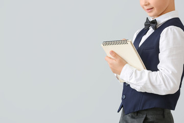 Wall Mural - Cute little waiter with notebook on light background