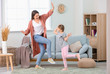 © Pixel-Shot - Happy mother and her little daughter dancing at home