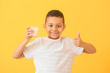 Poster - African-American boy with milk showing thumb-up on color background