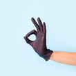 © misskaterina - Female hand in cosmetology medicine black glove pointing up okay, yes, accepting hand sign to the side, studio shot, copy space, banner for your flyer or site
