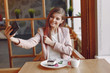 © hetmanstock2 - Girl in a cafe. Woman in a pink jacket. Lady have a breakfast.