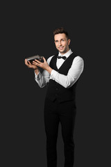 Wall Mural - Handsome male bartender on dark background