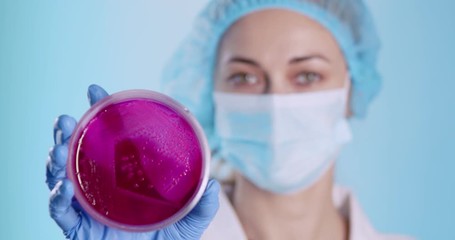 Poster - Scientist showing petri dish with sample on camera
