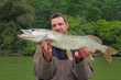 © sablin - Happy fisherman holding a big pike. Fishing scene