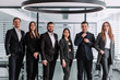 © newagecinema - A group of successful business people standing together in an office