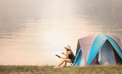 asian woman camping and tent outdoors near the lake.