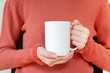 © photobuay - Mug mockup. Women's hands holding mug with blank space for your text or promotional content.