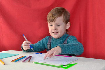 little boy drawing with color pencils