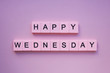 Happy wednesday words wooden cubes on a pink background