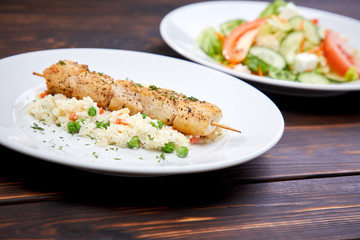 Wall Mural - chicken kebab with rice and vegetables on the wooden background