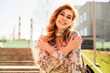© Вячеслав Чичаев - Portrait of a happy stylish beautiful woman with long hair on the background of the steps of the building in spring in the sun in bright weather.