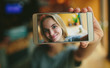 © estradaanton - Young blonde in a cafe. Shows smartphone in camera. On the screen her photo