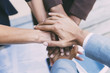 © Mangostar - Business team putting their hands together, expressing unity, support, friendship. Closeup of people stacking hands. Teamwork and success concept