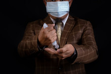 Asian Man Wearing Facial Hygienic Mask  Is Holding  Alchol Jel Bottle  For Hand Washing On Black Background.Anti-virus And Anti-COVID 19.Coronavirus.