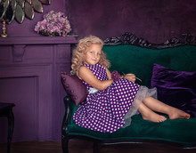 Cute Girl In A Purple Dress With White Polka Dots In A Purple Room
