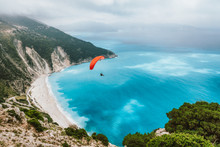 Summer Season Activity. Glider Flying Over Beautiful Myrtos Beach. Kefalonia Island, Greece. Amazing Water Colors And Mountain Coastline