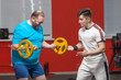 © satyrenko - A fat man in the gym performs barbell lifting exercises at the limit of his powers under the guidance of a personal trainer. Overweight