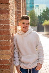 Wall Mural - Portrait of young male with hands on pocket leaning on wall outside