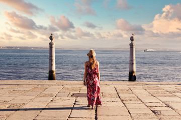 Wall Mural - Young tourist traveling through beautiful sunny european city and looking at view, rear view