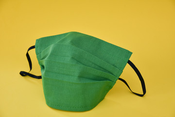 protective mask ,Homemade green face Mask -Coronavirus COVID-19) on yellow background