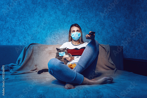 Fotomural the woman and the cat on the couch in front of the TV are both in protective med