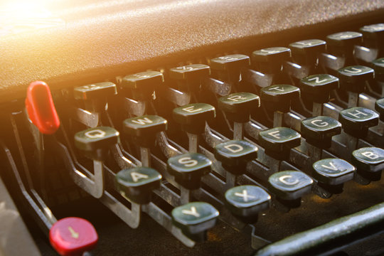 Keyboard of a retro typewriter, illuminated by sunlight.