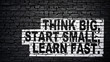 © Günter Albers - Think big, start small, learn fast, motivation and inspiration slogan, white text on black brick wall