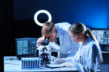 Scientist and student working in lab. Doctor teaching intern to make blood analyzing research. Coronavirus, vaccine research, bacteriology, virology and health care.