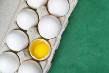 Paper Egg Tray With White Eggs. Chicken White Eggs Close Up. Broken Chicken White Egg. Eggs On Green Background