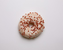 Donuts Topped With Icing Sugar And Sprinkled With Sugar, Pink Flakes Placed On A White Background Looks Delicious, But Be Careful Not To Eat As Much As Possible Because It Can Cause Obesity.