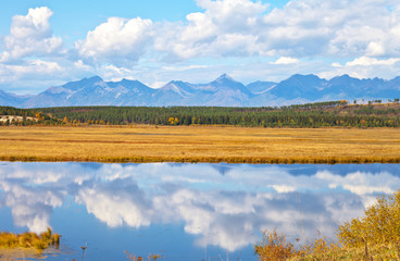 Wall Mural - a magnificent autumn landscape with reflection of clouds in the blue water of a pond. foothill valle