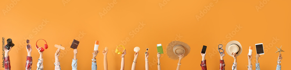 Many hands with travel items on color background - obrazy, fototapety, plakaty 