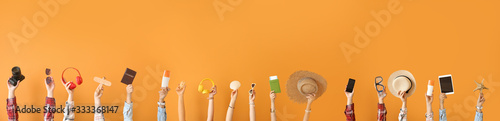 Fotografía Many hands with travel items on color background