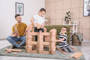 Wall Mural - Father and little children playing with take-apart house at home