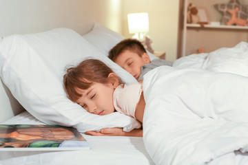 Canvas Print - Little girl with brother sleeping in bed at night