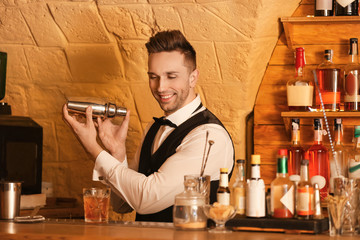 Wall Mural - Male bartender making cocktail in pub