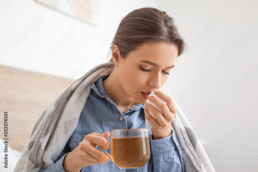 Ill woman drinking hot tea at home