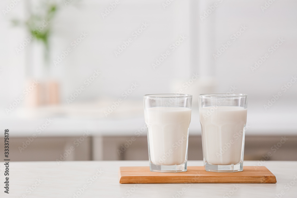 Glasses of fresh milk on table
