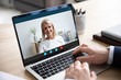 © fizkes - Head shot close up laptop screen view smiling attractive middle aged woman holding video call from home with male business partner, discussing working issues remotely online via videoconference app.