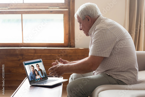 Cuadros en Lienzo Happy elderly mature 80s man holding video call with family grown up children and granddaughter, communicating online via laptop videoconference application, staying at home isolation, virus outbreak