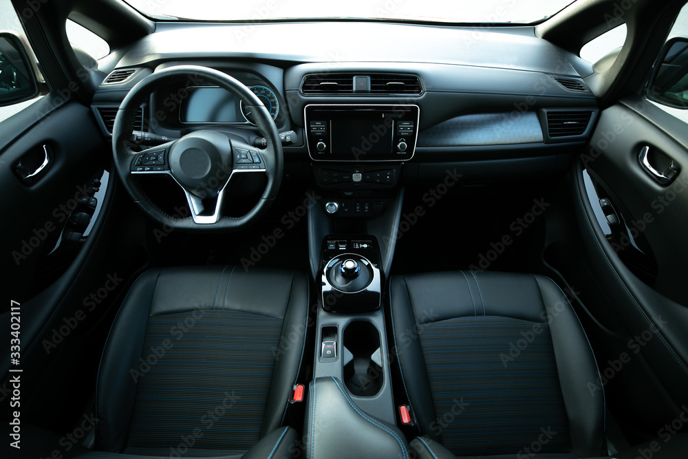 Electric car interior details of door handle with windows controls and adjustments. Inside car interior with front seats, driver and passenger, textile, windows, door panels, console - obrazy, fototapety, plakaty 