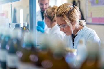 beautiful young woman scientist in laboratory working. young female scientist doing some research.