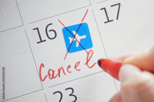Fotomural Close-up of unrecognizable person with red felt-tip pen cross out the note on calendar surface symbolizing scheduled flight