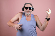 A Hipster Aged Man In Grey Hat, Blue Tank Top, Sunglasses And Headphones Playing Vigorously On An Imaginary Guitar. Stunning Solo On Invisible Guitar