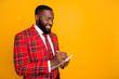 © deagreez - Photo of attractive attentive dark skin guy hold planner writing new startup project idea wear checkered red costume blazer shirt tie isolated yellow color background