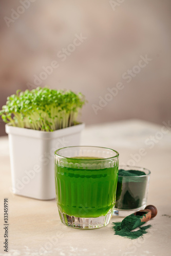 Fototapeta na drzwi i meble Glass of spirulina drink powder on table. Food and drink, dieting and nutrition concept.