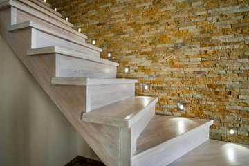 Sticker - Stylish wooden contemporary staircase inside loft house interior. Modern hallway with decorative limestone brick walls and white oak stairs.