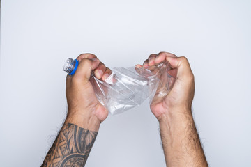  Man hand grab and twist plastic bottle for recycle. Eco system.